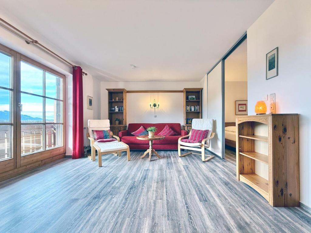 a living room with a red couch and chairs at Sonnenhof Seeg 08 in Seeg