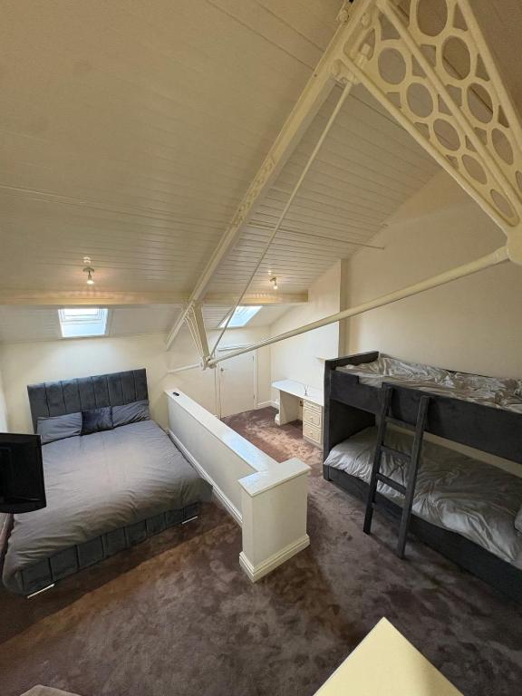 a attic bedroom with two beds and a desk at Dock View Lodge in Liverpool
