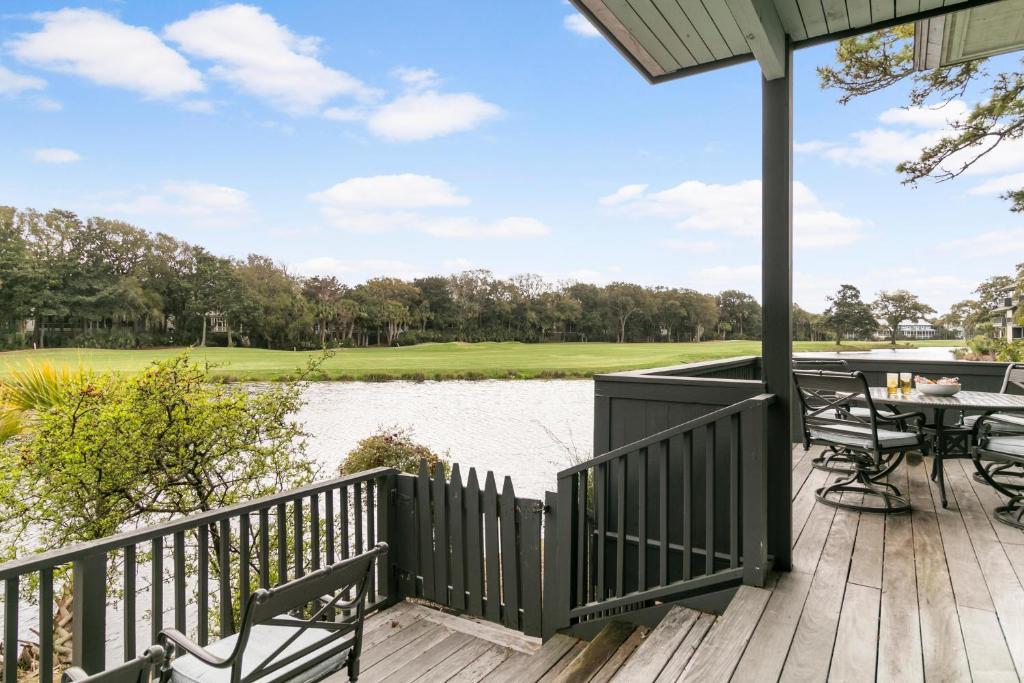 a deck with a table and chairs next to a lake at 4910 Green Dolphin in Kiawah Island