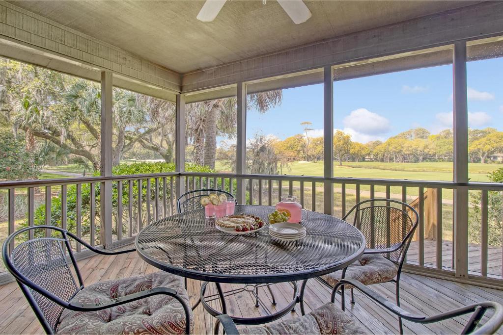 a table and chairs on a screened in porch with a table at 273 Summer Tanager in Kiawah Island
