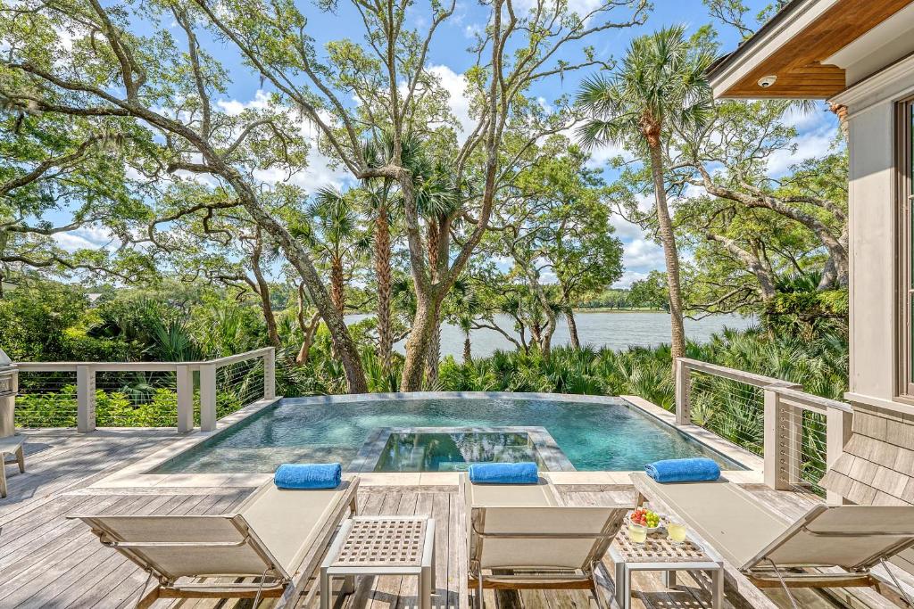 a swimming pool on a deck with chairs and a table at 68 New Settlement in Kiawah Island