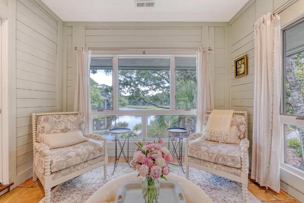 a room with two chairs and a table with a vase of flowers at 4925 Green Dolphin in Kiawah Island