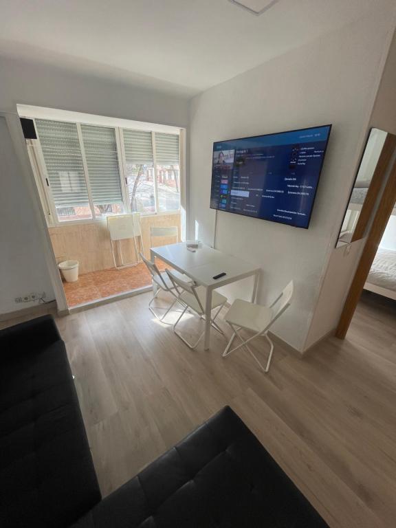 a living room with a table and chairs and a television at Piso en Calle Albares De La Ribera in Madrid