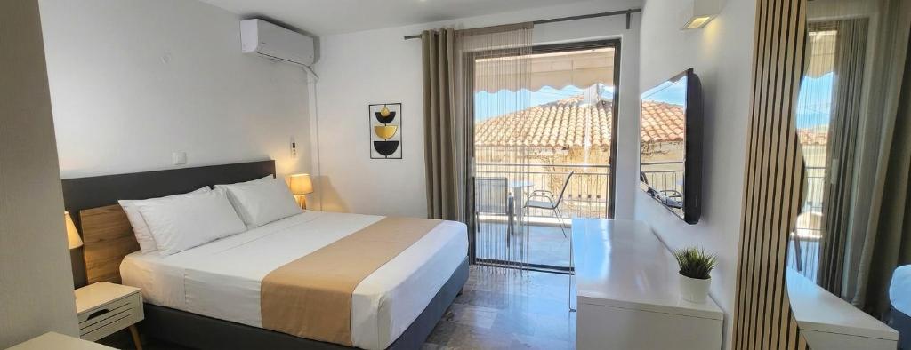 a hotel room with a bed and a balcony at Mare Vento in Kiveri