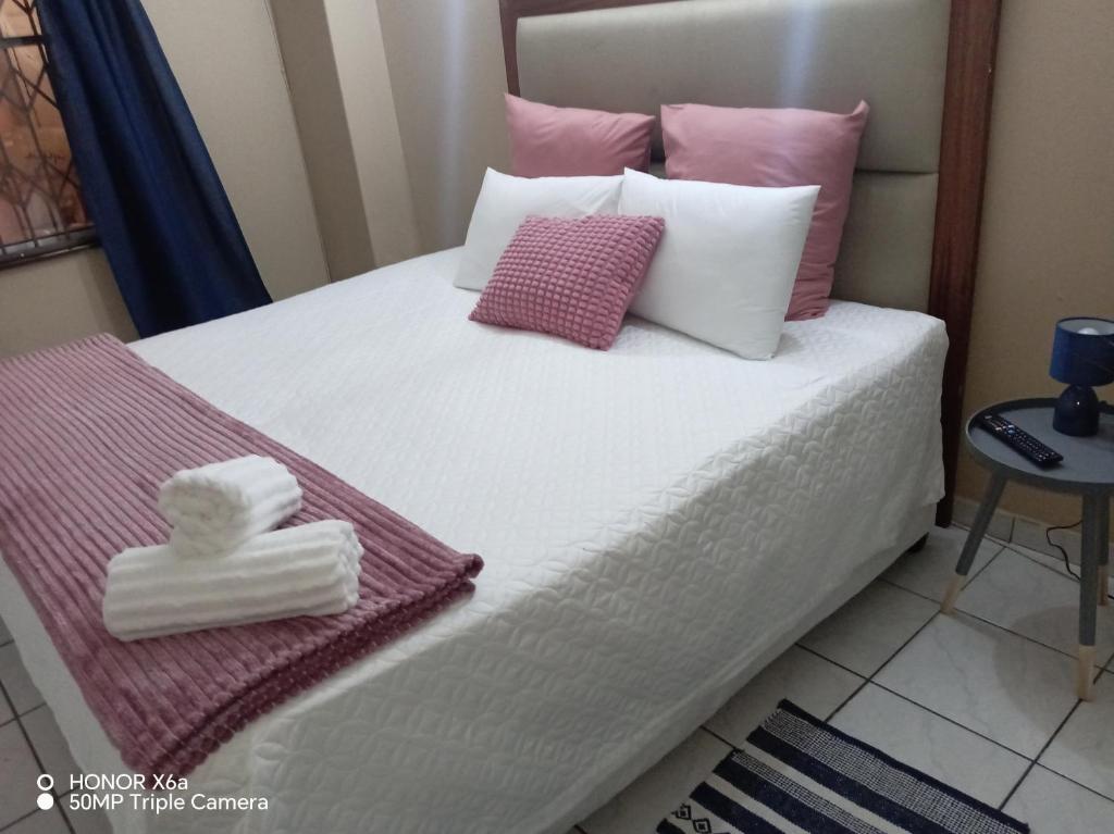 a bedroom with a bed with pink and white pillows at The Glen House in Durban