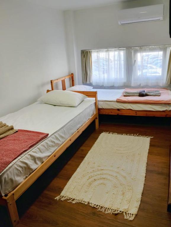 two twin beds in a room with a rug at GuestHouse2 Karma369 in Plovdiv
