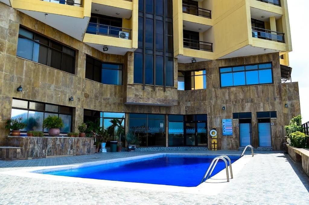 a swimming pool in front of a building at Hotel arimaca in Ríohacha