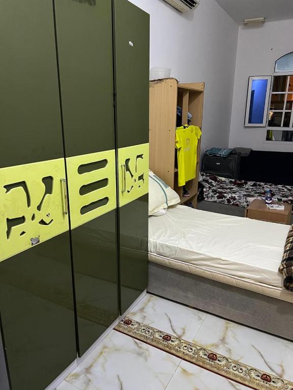 a room with a bed in a room with a locker at BRAZIL House in Muscat