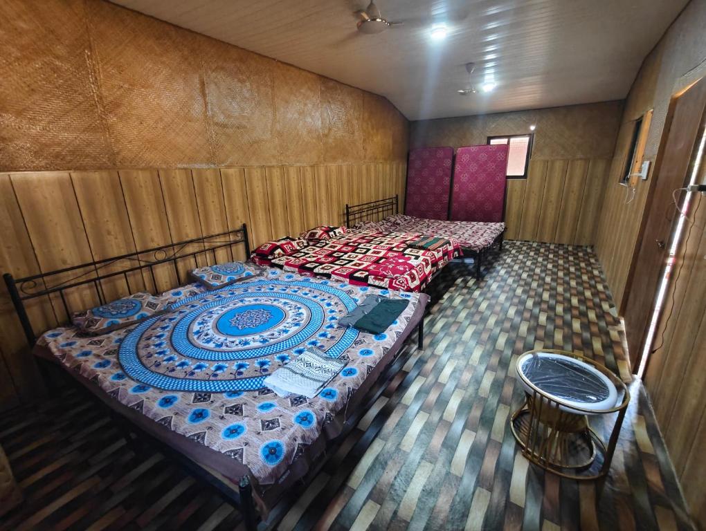 a bedroom with two beds and a stool in it at victory farms in Nadora