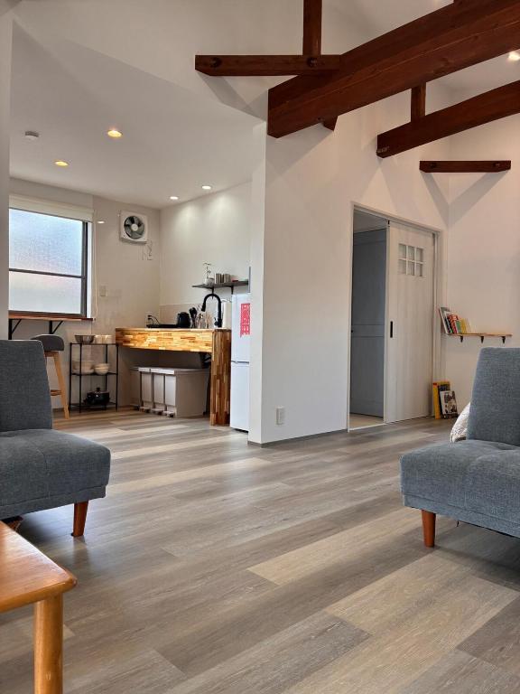 a living room with two couches and a kitchen at 細島 Base Clutch in Hyuga
