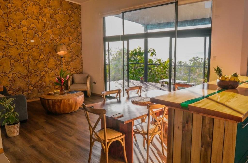 a living room with a table and chairs and a large window at Te Manu Lodge in Hanga Roa
