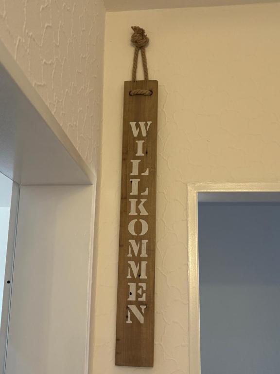 a wooden sign hanging on a wall next to a door at Henneberger Hof Wildlife in Münnerstadt