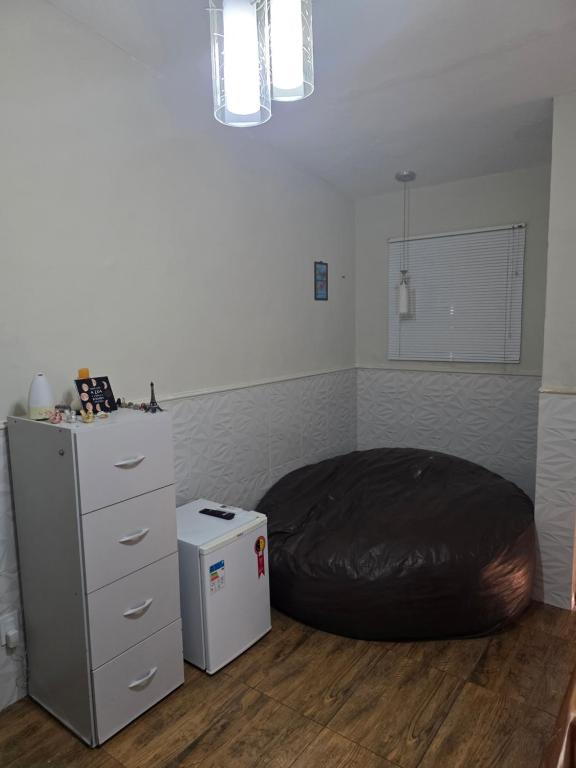 a bedroom with a bean bag bed and a dresser at Quarto Ametista in Aracaju