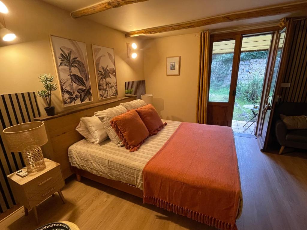 a bedroom with a bed with an orange blanket at Chambres d'Hôtes Barraconu in Porto-Vecchio