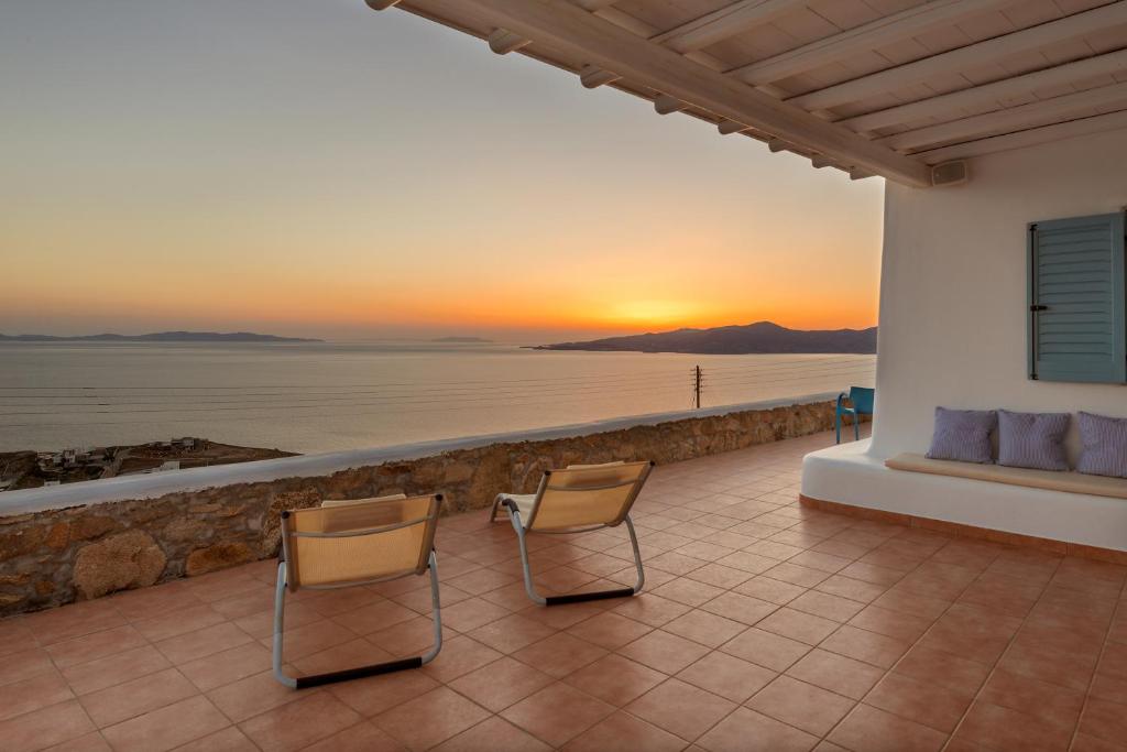 a patio with chairs and a view of the ocean at Lighthouse Villa - Private Pool - Unlimited Sea View - 6 pax in Houlakia