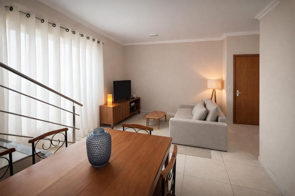 a living room with a table and a couch at Apê 301 - Central, Garagem, Ar-Cond - 2 Quartos in Governador Valadares