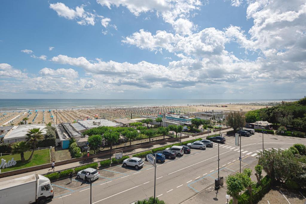 a parking lot with parked cars and the beach at Hotel Rudy Cervia in Cervia