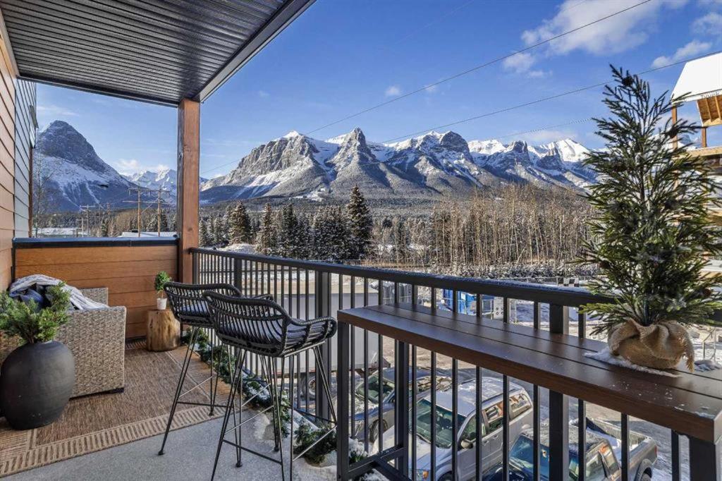 a balcony with a table and chairs and mountains at New Luxury 3 bedroom in Canmore