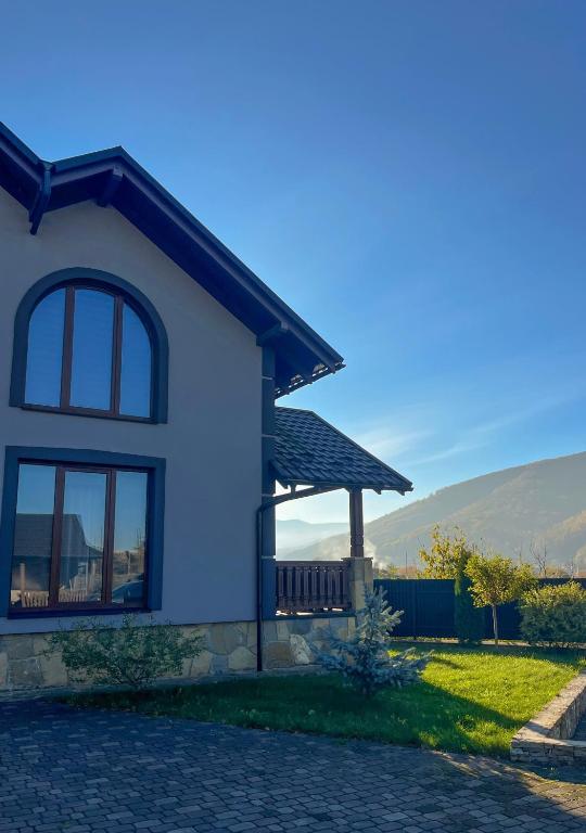 a white house with a porch and a bench at Gray house in Yaremche