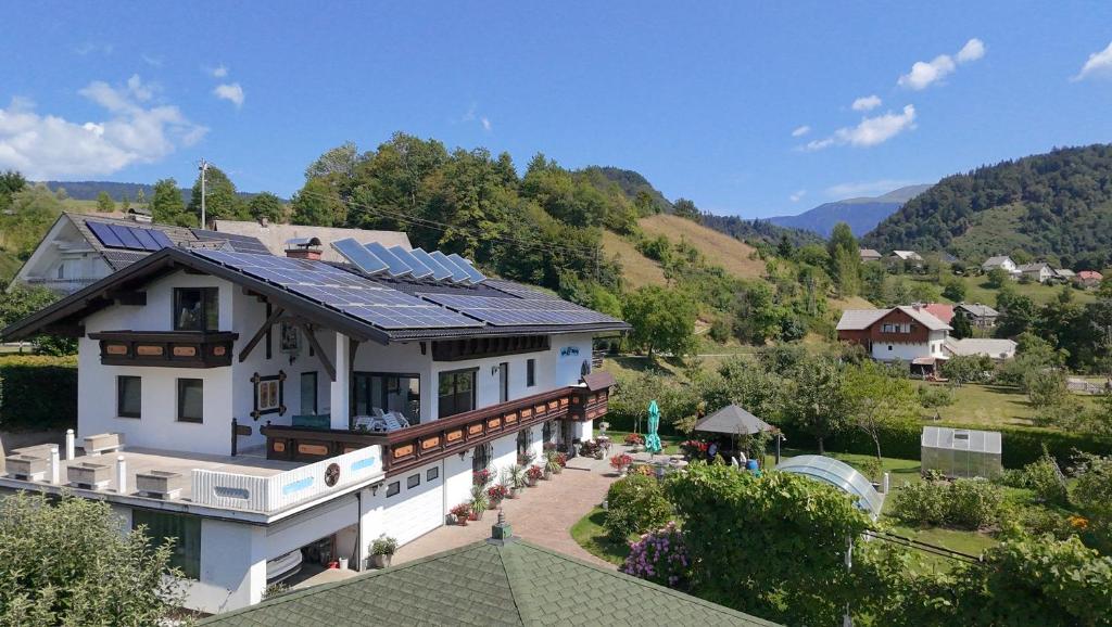 a house with solar panels on top of it at Apartments AlpRoza in Zgornje Gorje