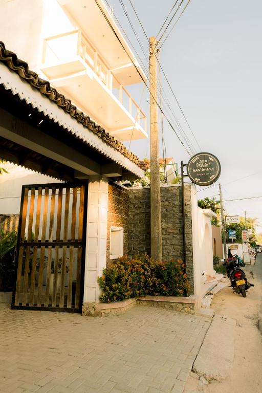 a building with a gate and flowers in front of it at Cafe San-Khara in Ahangama