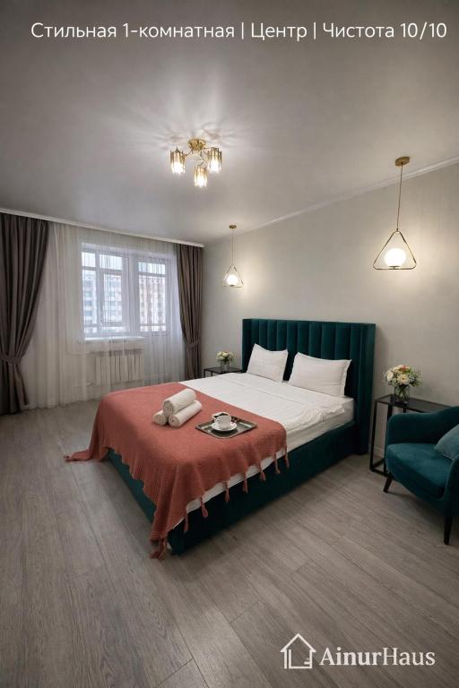 a bedroom with a large bed with a red blanket at Аблайхана 1 г in Kokshetau