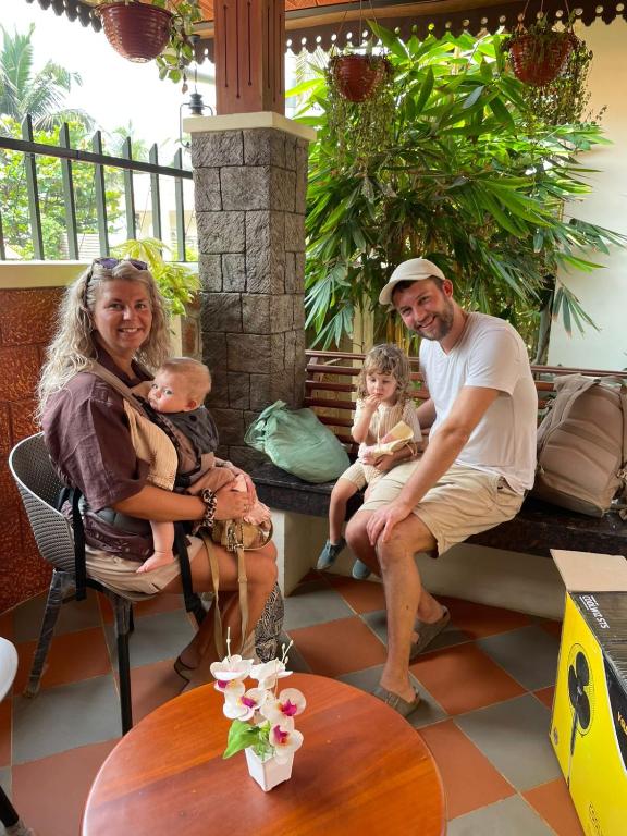 a man and a woman and two children sitting on a table at Adonna Beach Resort in Alleppey
