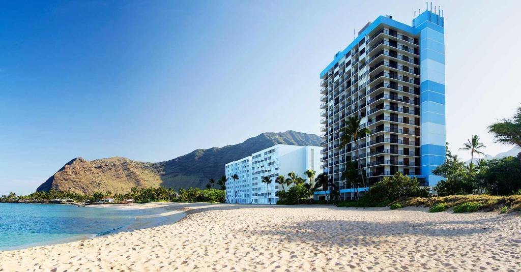 a view of a beach with a building and the ocean at Hawaiian Princess Makaha in Waianae