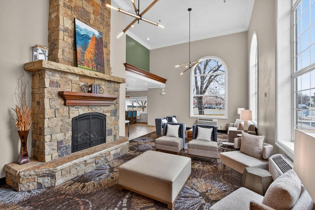 a living room with a large stone fireplace at Best Western Timpanogos Inn in Lehi