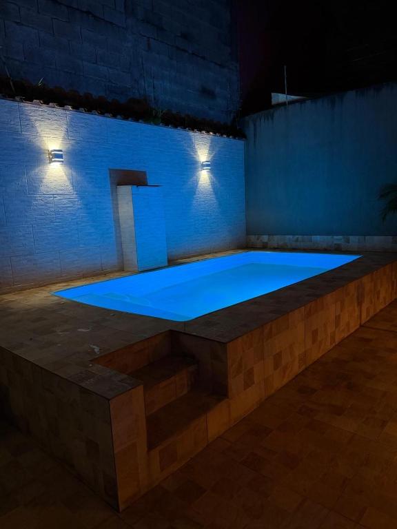 a large swimming pool in a room at night at Casa em Condomínio in Bertioga