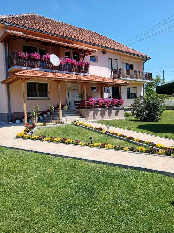 a house with a flower garden in front of it at Etno Kuća Jaćimović 1 in Pranjani