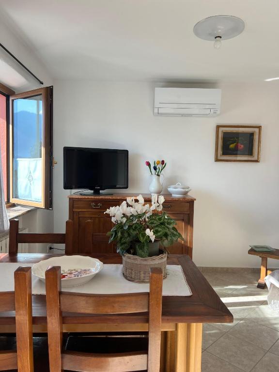 a living room with a table and a tv at Casetta al Belvedere - Lake View in Vercana