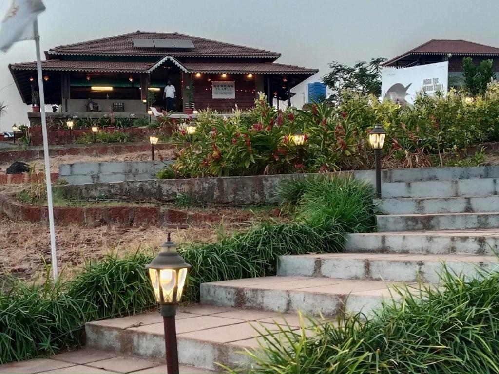 a set of stairs leading to a building with lights at Fulora Guesthouse in Dapoli