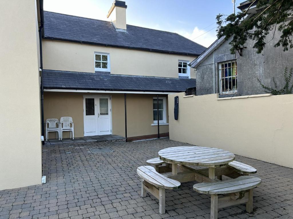a picnic table and two benches in front of a building at Number 6 Bank House in Schull
