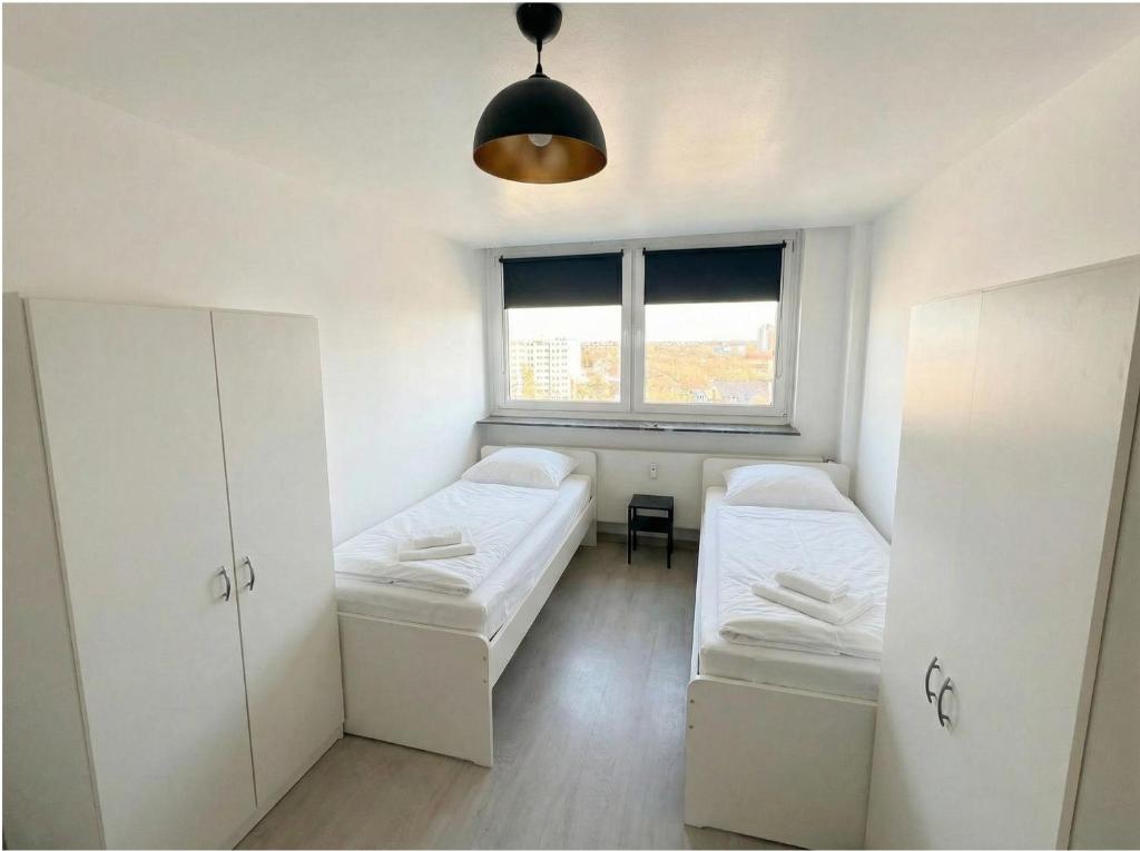 a small room with two beds and a window at CityNest Apartment Dortmund in Dortmund