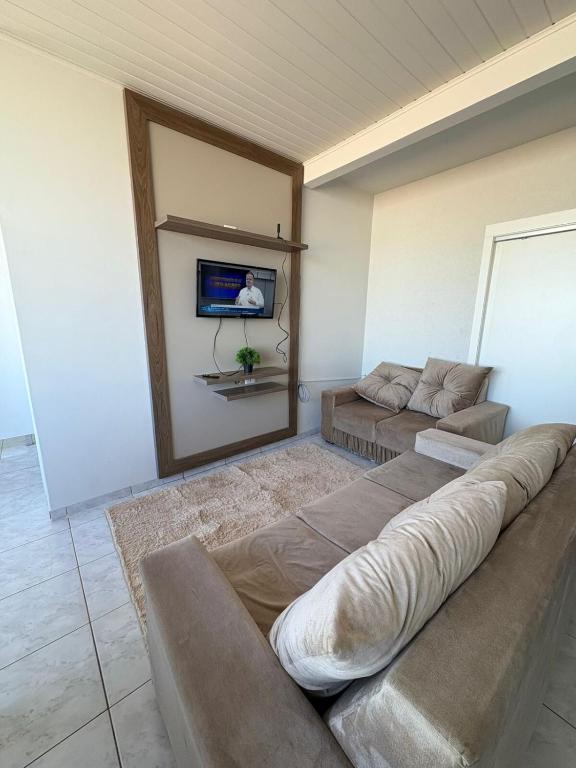 a living room with a couch and a flat screen tv at Loft J&C 01 in Primavera do Leste