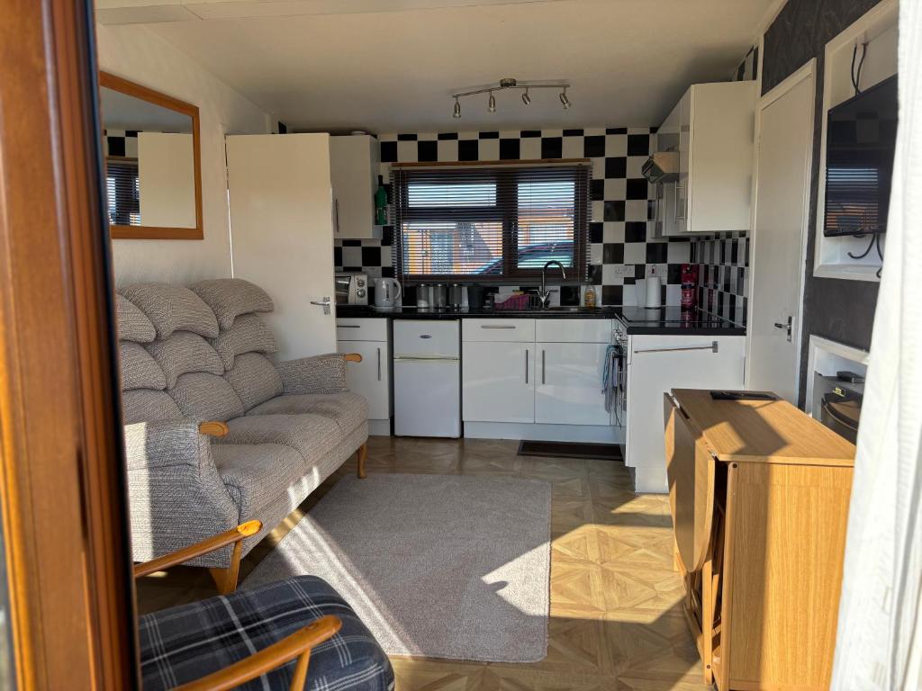 a living room with a couch and a kitchen at g11 chalet in Mablethorpe