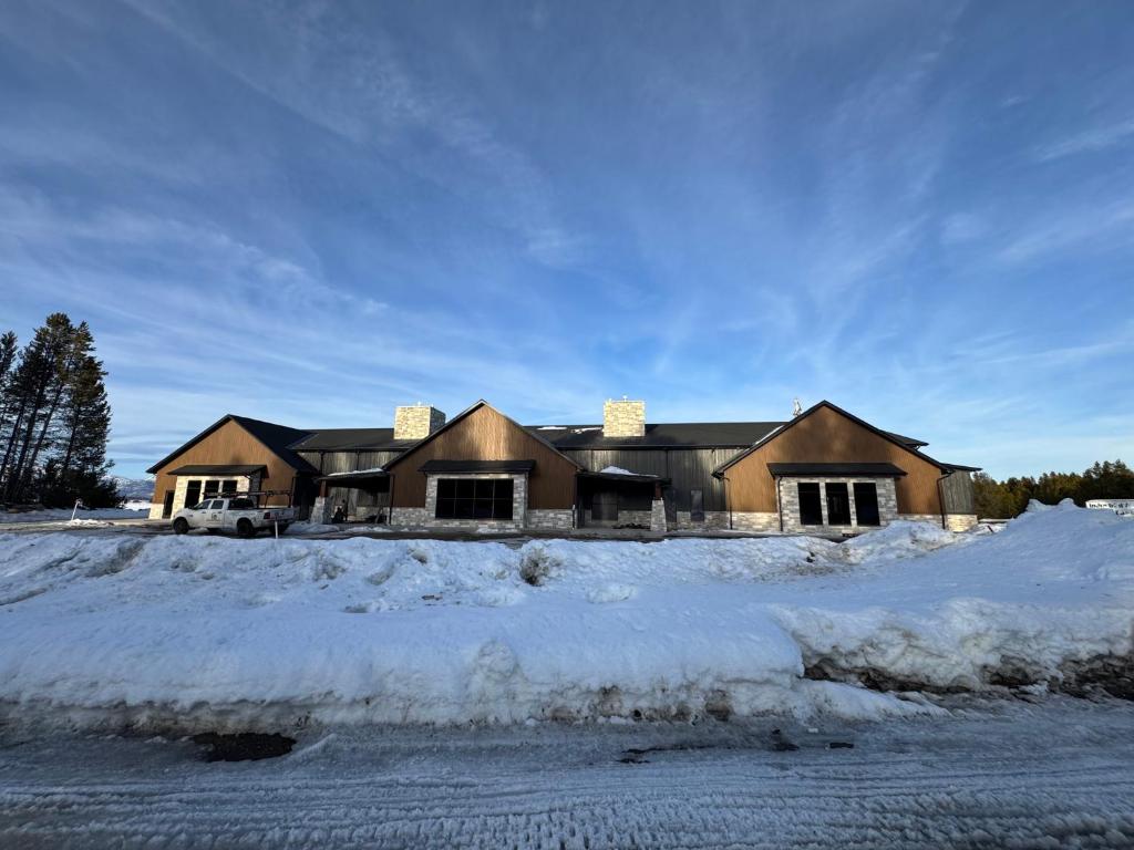 a house in the snow with snow covered ground at Yellowstone Springs Resort in Island Park