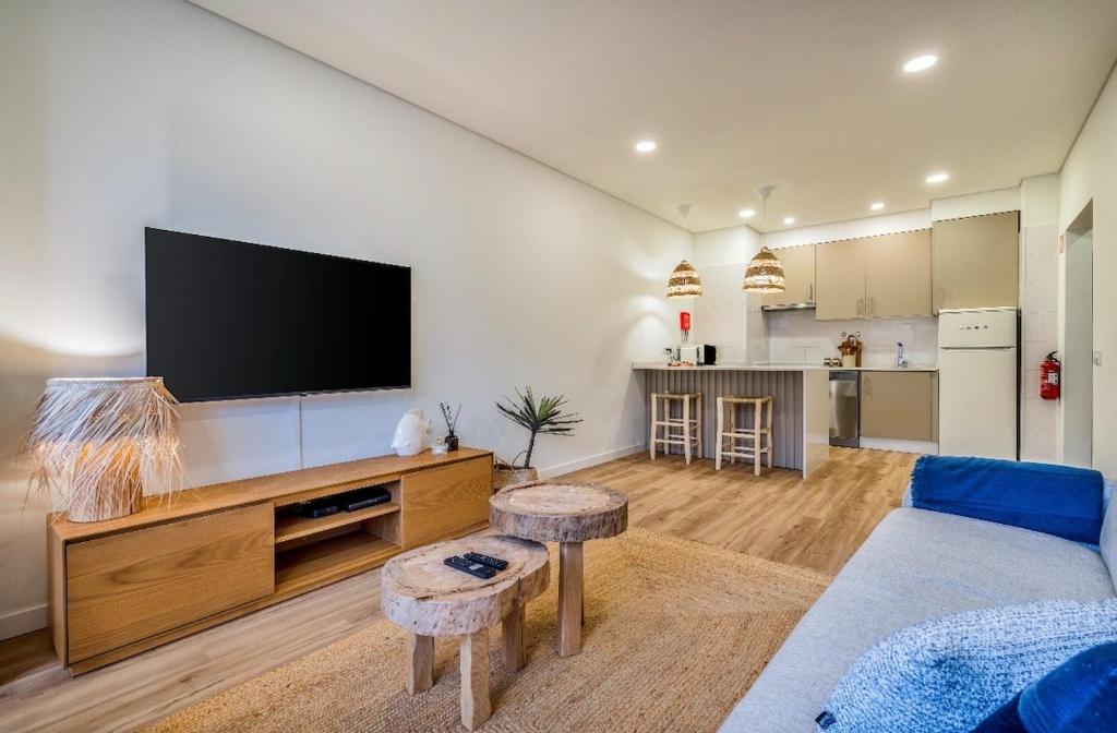 a living room with a flat screen tv on a wall at Brisa do Mar in Quarteira