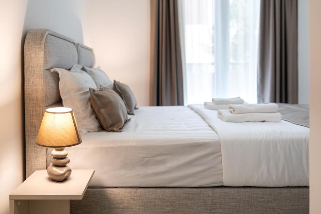 a bedroom with a white bed with a lamp and a window at Hotel Podostrog - New Comfort 2026 in Budva