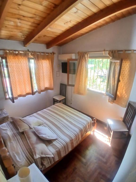 a bedroom with a bed and two windows at Departamento Independiente con Terraza in La Cieneguita