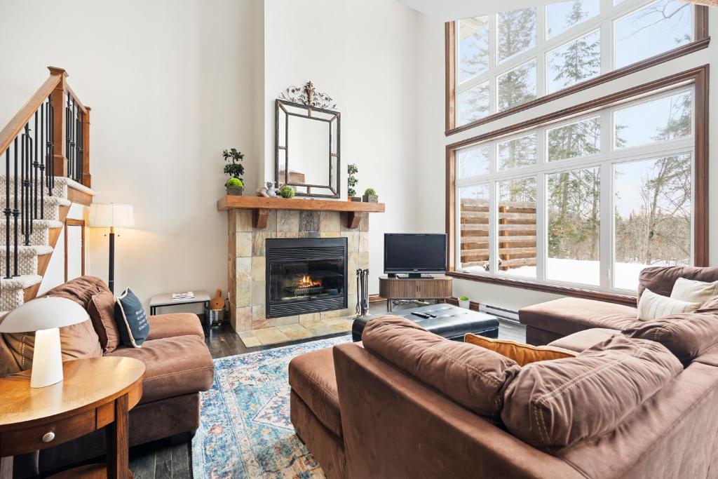 a living room with two couches and a fireplace at Townhouse On The Golf La Bte -10min To Tremblant in Mont-Tremblant