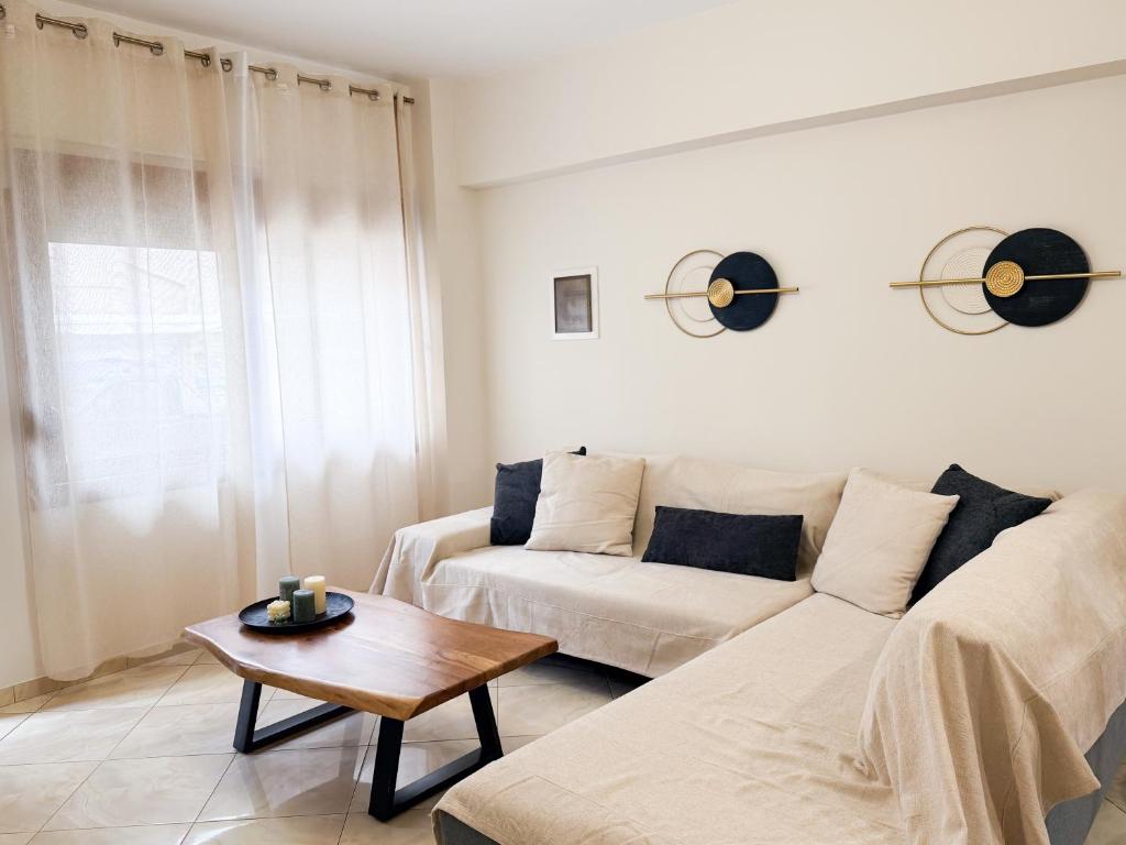 a living room with a white couch and a table at Thalori Home Georgioupolis in Georgioupolis