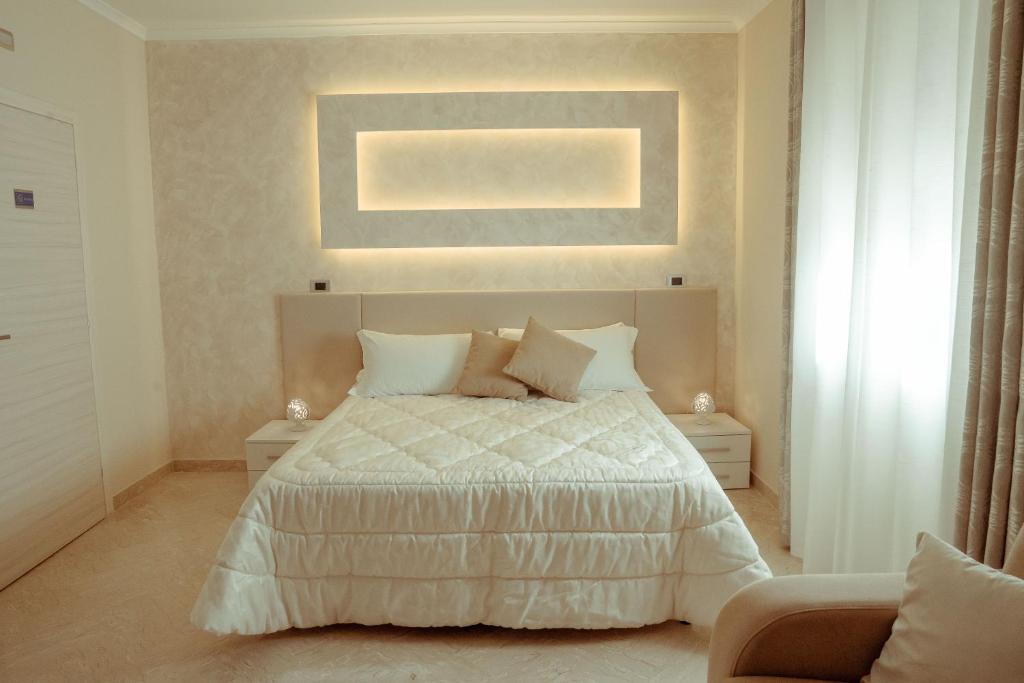 a bedroom with a bed with white sheets and pillows at Villa Enza B&B in Ginosa