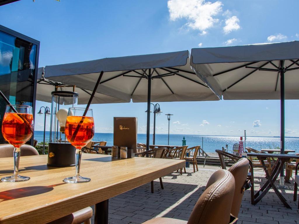 a wooden table with wine glasses on the beach at Hof Sierksdorf in Sierksdorf