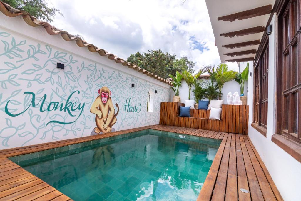 a swimming pool with a mural of a monkey on a wall at Condominio The monkey House in Villa de Leyva