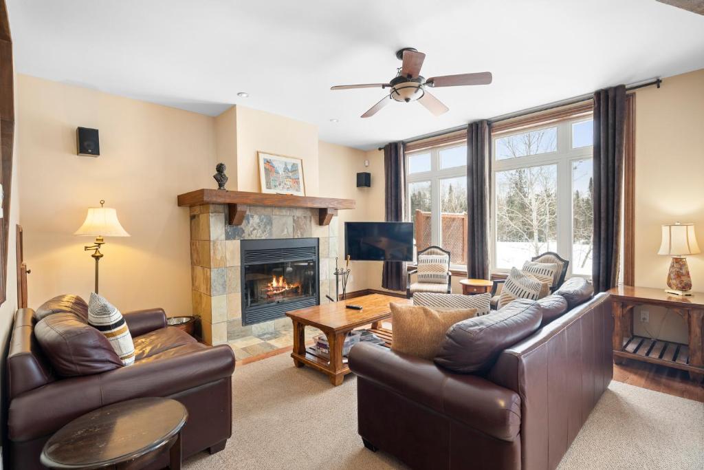 a living room with leather furniture and a fireplace at House On The Golf La Bte -10min To Tremblant 150 in Mont-Tremblant