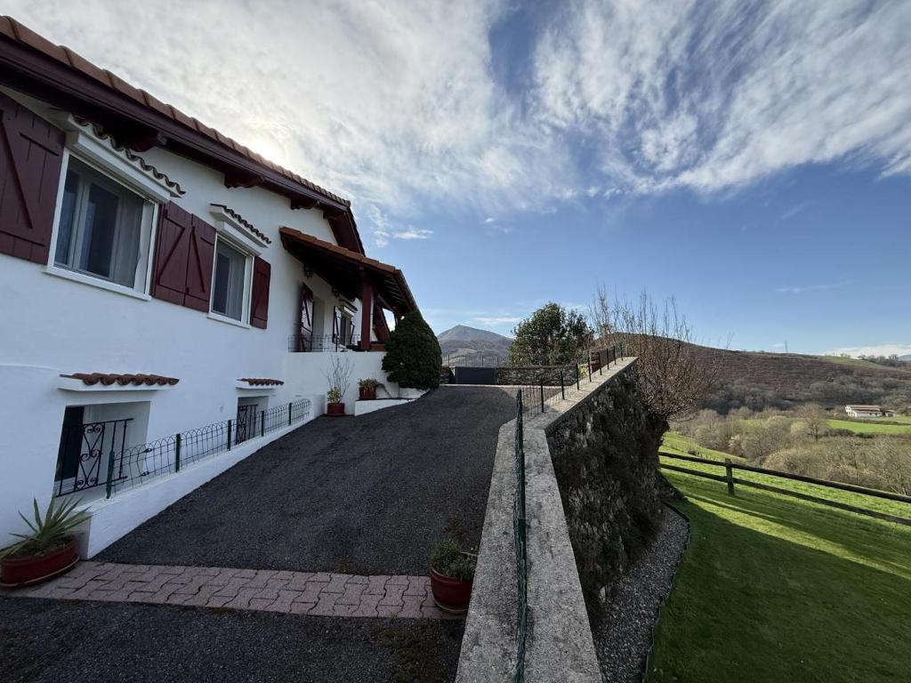 a road leading to a white house with a fence at Aguerrea in Macaye