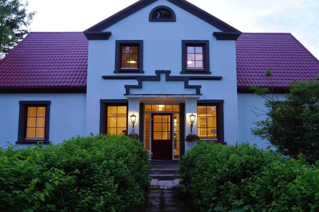 a blue house with a purple roof at Virulase Holiday Home in Toila