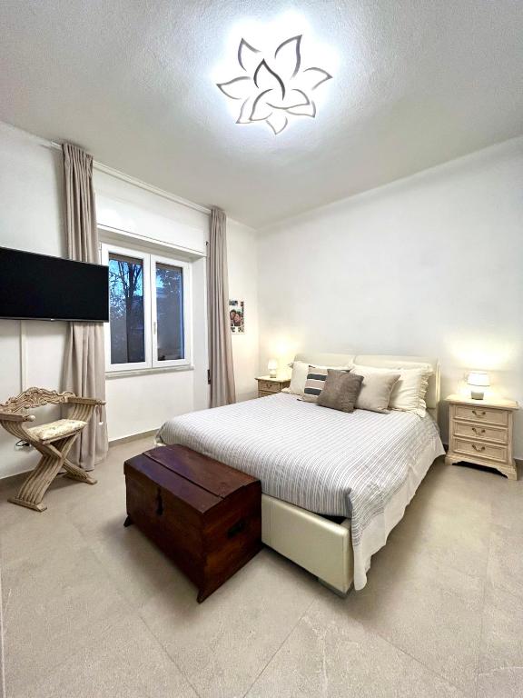a bedroom with a large bed and a chandelier at Princess Home in Marina di Massa